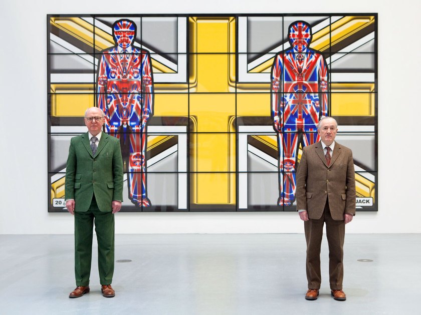 Gilbert & George standing in front of ‘Metal Jack’ (2008) from the series ‘Jack Freak Pictures’ on show at Deichtorhallen Hamburg