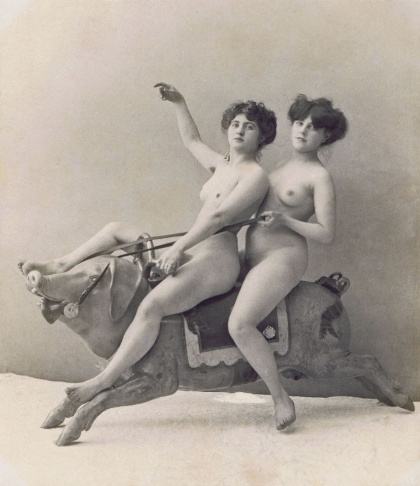Photographer unknown. 'Two women on a carousel Pig' c. 1900