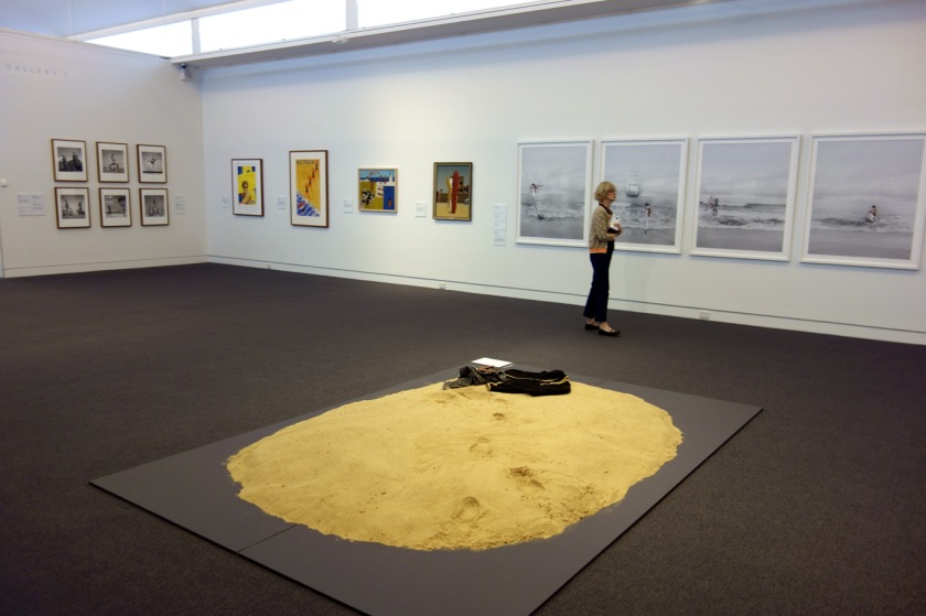 Installation view of the exhibition 'On the beach' at the Mornington Peninsula Regional Art Gallery with in the foreground, Leanne Tobin's 'Clothes don't always maketh the man' (2012), and in the background right, photographs from Michael Cook's 'Undiscovered' series (2010)