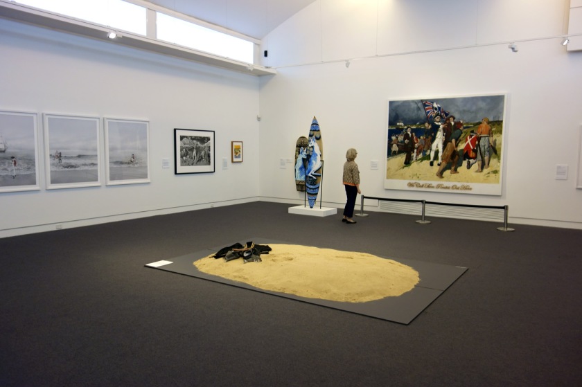 Installation view of the exhibition 'On the beach' at the Mornington Peninsula Regional Art Gallery with in the foreground, Leanne Tobin's 'Clothes don't always maketh the man' (2012), and in the background left, photographs from Michael Cook's 'Undiscovered' series (2010)