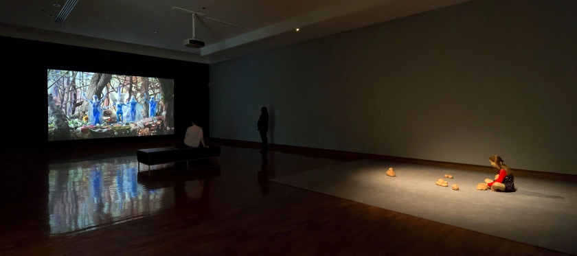 Installation view of the exhibition 'All the better to see you with: Fairy tales transformed' at The Ian Potter Museum of Art, Melbourne showing a still from Allison Schulnik's video 'Eager' (2013-2014) at left, and Patricia Piccinini's 'Still Life with Stem Cells' (2002) at right