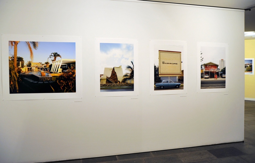 Installation view of the exhibition 'John Gollings: The history of the built world' at the Monash Gallery of Art showing at left, 'El Dorado Motel, Surfers Paradise, Queensland' 1973; second left, 'Golden Sun Motel, Surfers Paradise, Queensland' 1973; second right, 'Biscayne Apartments, Surfers Paradise, Queensland' 1973; and right, 'Cuba Flats, Surfers Paradise, Queensland' 1973