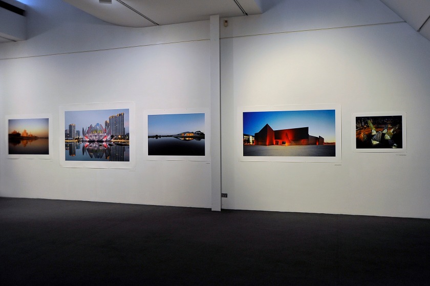 Installation view of the exhibition 'John Gollings: The history of the built world' at the Monash Gallery of Art showing at second left, 'The Lotus Building (Studio 505), Changzhou, China' 2013; third left, 'Croft House (James Stockwell), Inverloch, Victoria' 2013; second right, 'Australian Centre for Contemporary Art (Wood Marsh), Southbank, Victoria' 2002; and right, 'Habitat filter (Matt Drysdale, Matt Myers and Tim Dow), Southbank, Victoria' 2017