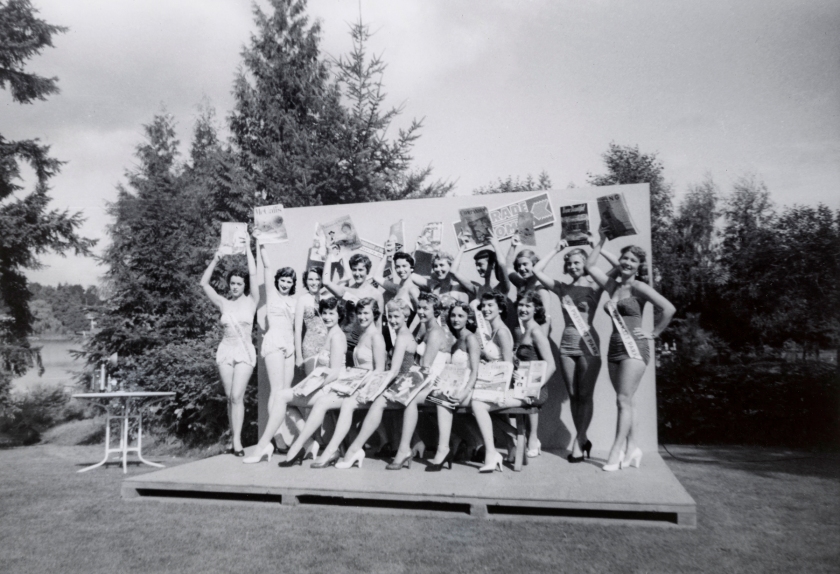 Photographer Unidentified (American) 'Untitled (seventeen women in swimsuits hold magazines up on a low stage on a lawn)' 20th century (c. 1950s)