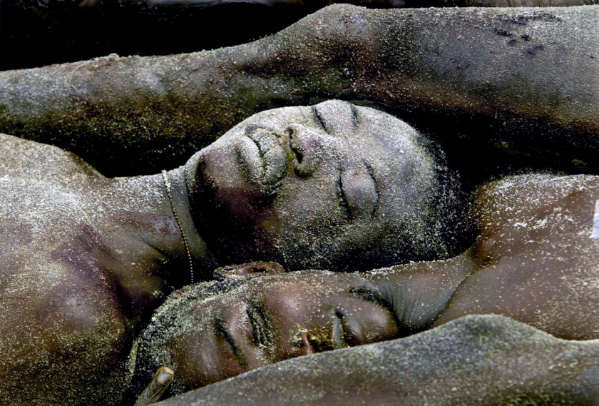 Carolyn Cole (American, b. 1961) 'Dozens of bodies are laid in a mass grave on the outskirts of Monrovia, Liberia' August 2003