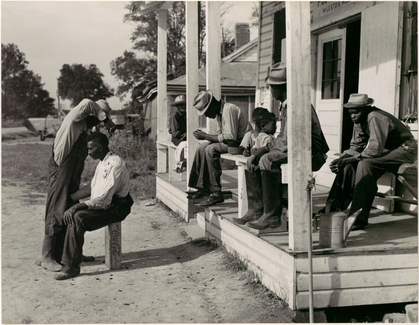 Marion Post Wolcott (American, 1910-1990) '[Haircutting in Front of General Store and Post Office on Marcella Plantation, Mileston, Mississippi]' 1939