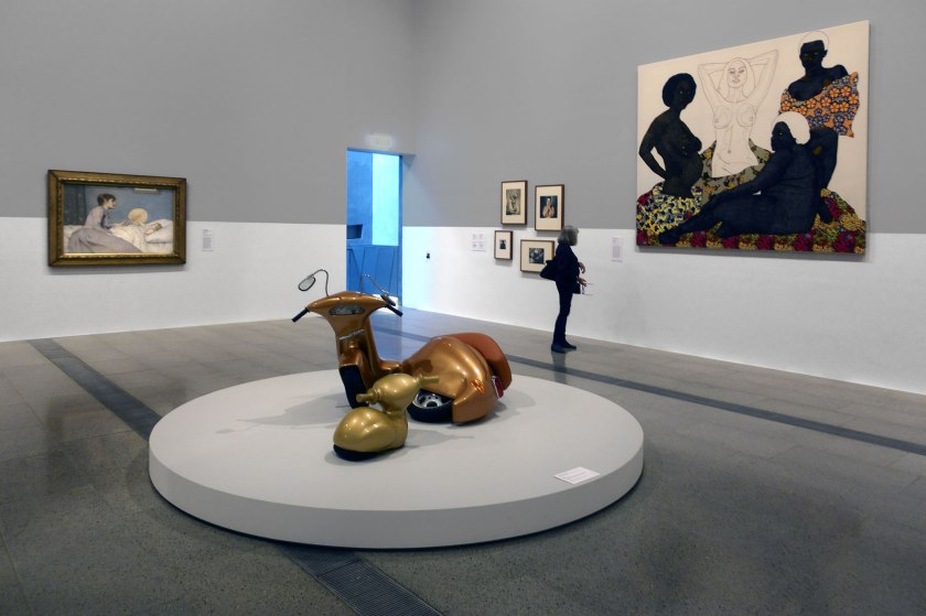 Installation view of the exhibition 'WHO ARE YOU: Australian Portraiture' at NGV Australia, Federation Square, Melbourne showing at left, John Longstaff's 'The young mother' (1891); at centre Patricia Piccinini's 'Nest' (2006); at second right, a group of four photographs one by each of Jack Cato, Virginie Grange, Olive Cotton and Athol Shmith; and at right Pierre Mukeba's 'Impartiality' (2018)