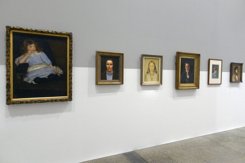 Installation view of the exhibition 'WHO ARE YOU: Australian Portraiture' at NGV Australia, Federation Square, Melbourne with at left, E. Phillips Fox's 'Dolly, daughter of Hammond Clegg Esq.' (1896); at second left, Nora Heysen's 'Self portrait' (1934); and at third right, Florence Fuller's 'Paper Boy' (1888)