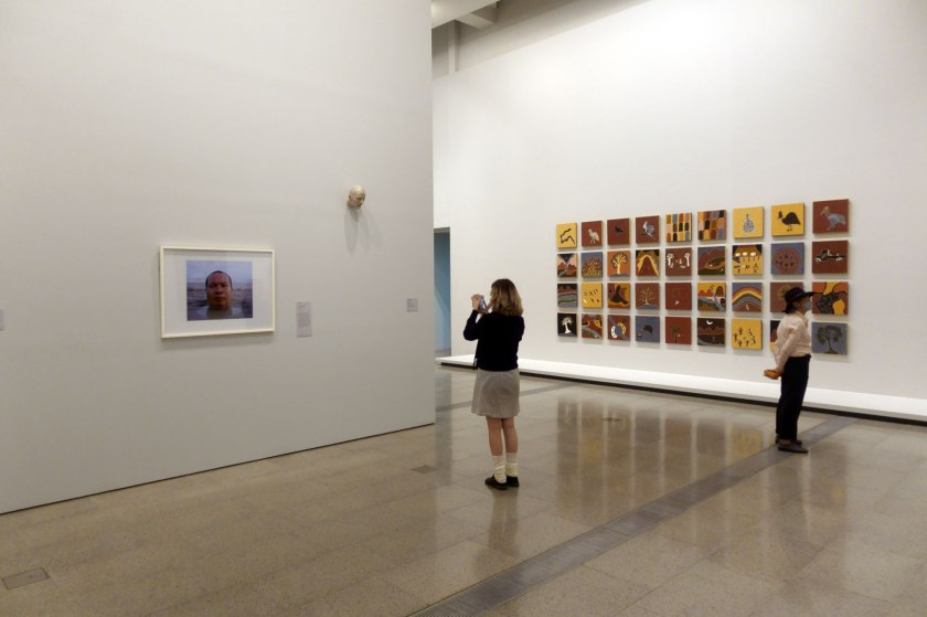 Installation view of the exhibition 'WHO ARE YOU: Australian Portraiture' at NGV Australia, Federation Square, Melbourne showing at right, Shirley Purdie's 'Ngalim-Ngalimbooroo Ngagenybe' (2018)