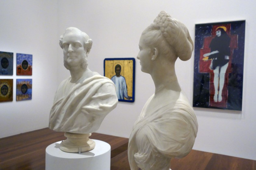 Installation view of the exhibition 'WHO ARE YOU: Australian Portraiture' at NGV Australia, Federation Square, Melbourne showing at centre on pedestal, Charles Summers' 'Edmund FitzGibbon and Sarah FitzGibbon' (1877); at centre background, AñA Wojak's 'Acacius (Stigmata) – Tony Carden' (1991); and at right, Julie Rrap's 'Persona and shadow: Madonna' (1984)
