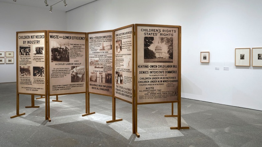 Installation view of the exhibition 'Documentary Genealogies: Photography 1848-1917' at the Museo Nacional Centro de Arte Reina Sofía, Madrid showing at centre Lewis Hine exhibition panels 1913-1914