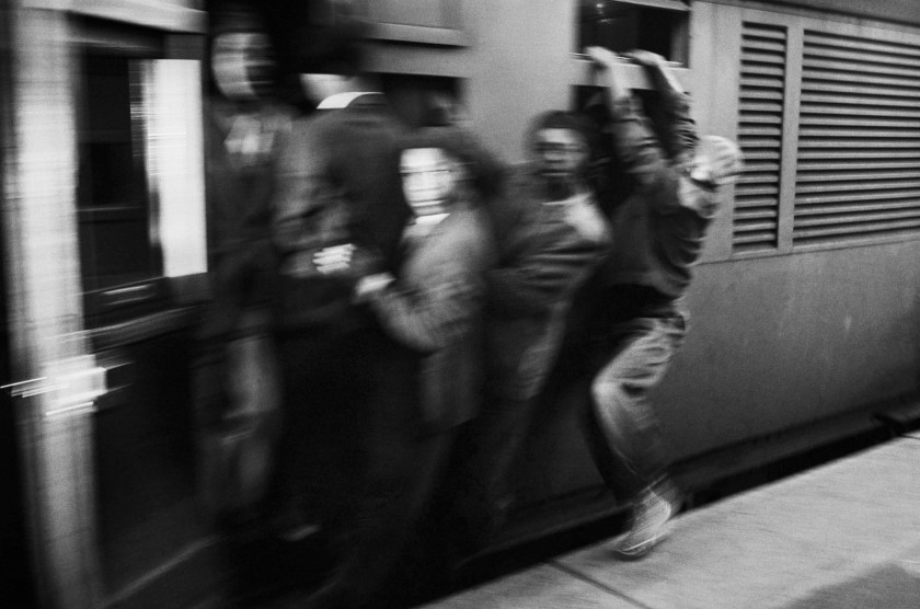Ernest Cole (South African, 1940-1990) 'SOUTH AFRICA. 1960s. Africans throng Johannesburg station platform during late afternoon rush hour. The train accelerates with its load of clinging passengers. They ride like this through rain and cold, some for the entire journey' 1960-1966