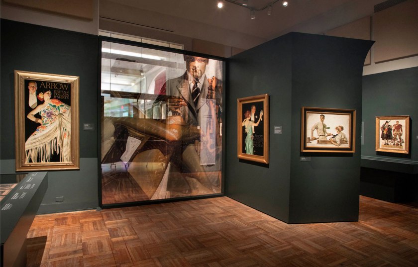 Installation view of the exhibition 'Under Cover: J.C. Leyendecker and American Masculinity' at the New-York Historical Society showing at third right, 'Man and Woman Dancing' (1923); at second right, 'Couple in Boat' (1912); and at right, 'Thanksgiving: 1628-1928 (Pilgrim and Football Player)' (1928)