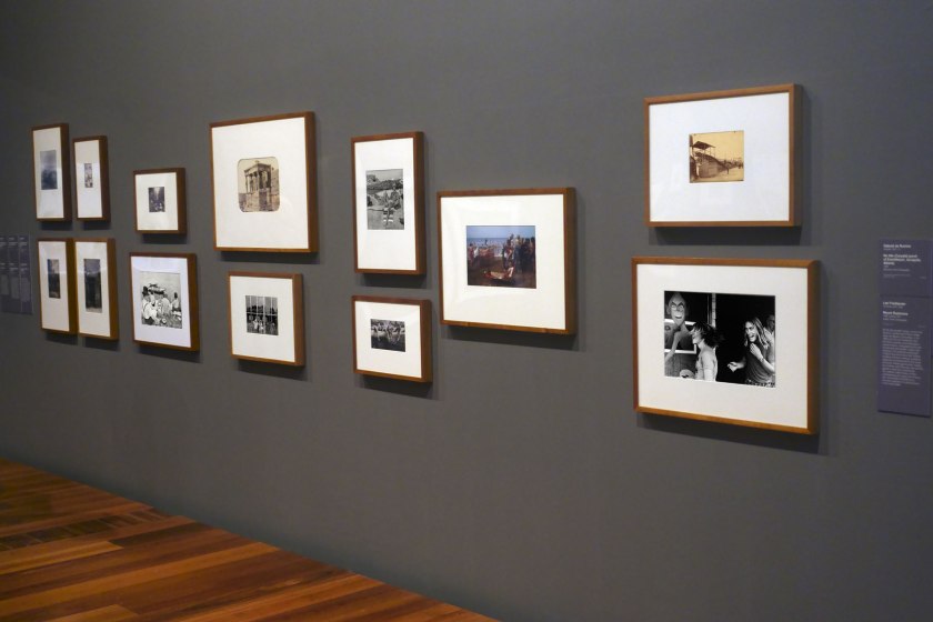 Installation view of the exhibition 'Photography: Real & Imagined' at The Ian Potter Centre: NGV Australia, Melbourne showing at third left bottom, Henri Cartier-Bresson's 'Sunday on the banks of the Marne' (1938, below); at fourth left top, Gabriel de Rumine’s 'Caryatid porch of Erechtheum, Acropolis, Athens' (1859, below); at fourth left bottom, Lee Friedlander's 'Mount Rushmore' (1969, below); at centre top, John Williams' 'Clovelly Beach, Sydney' (1969, below); at top right, Eugène Atget's 'The roller coaster, Invalides funfair (Montagnes russes, fête des Invalides)' (1898, below); and at bottom right, Roger Scott's 'Ghost train, Sydney Royal Easter Show' (1972? 1975? below)