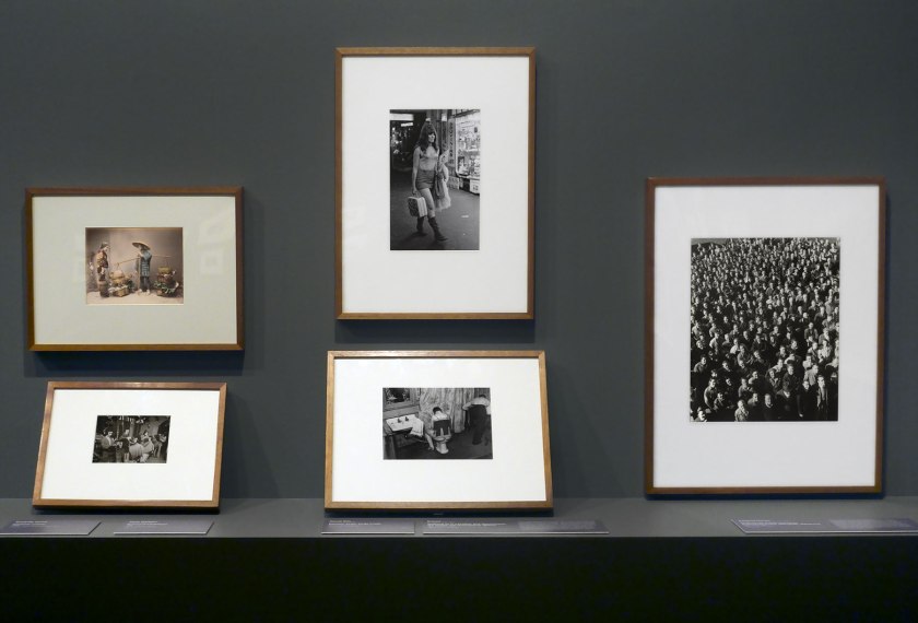Installation view of the exhibition 'Photography: Real & Imagined' at The Ian Potter Centre: NGV Australia, Melbourne showing at top left, Kusakabe Kimbei's 'Vegetable peddler' (1880s, below); at bottom left, David Wadelton's 'Richmond hairdresser' (1979, below); at top centre, Rennie Ellis' 'Between strips, Kings Cross' (1970-1971, below); at bottom centre, Brassai's 'Washing up in a brothel, Rue Quincampoix (La Toilette, rue Quincampoix (Bidet))' (1932, below); and at right, Wolfgang Sievers' 'Shiftchange at Kelly and Lewis engineering works, Springvale, Melbourne' (1949, below)