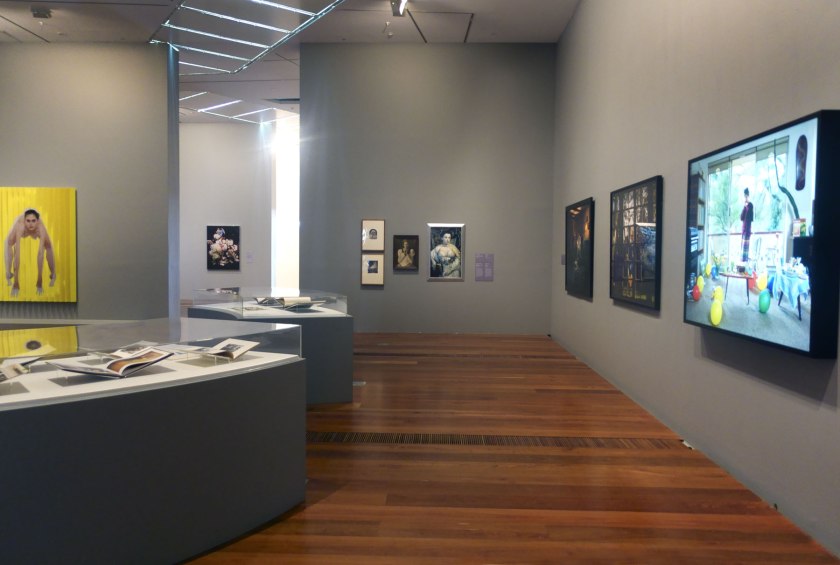 Installation view of the exhibition 'Photography: Real & Imagined' at The Ian Potter Centre: NGV Australia, Melbourne showing at left, Polly Borland's 'Untitled' (2018); and at right, Anne Zahalka's 'Sunday, 2:09pm' (1995)