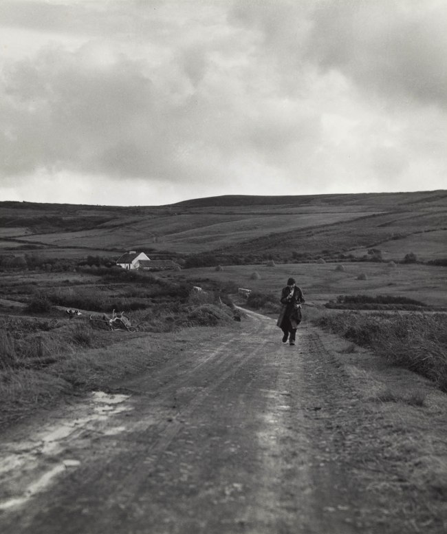 Dorothea Lange (American, 1895-1965) 'Man Walking Down a Country Road from the Kenneally Family Farm, County Clare, Ireland' from 'The Irish Countryman' 1954