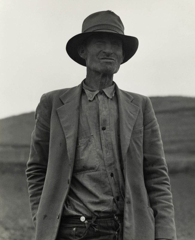 Dorothea Lange (American, 1895-1965) 'This man is a labor contractor in the pea fields of California. "One-Eye" Charlie gives his views. "I'm making my living off of these people (migrant laborers) so I know the conditions," San Luis Obispo County, California' February 1936