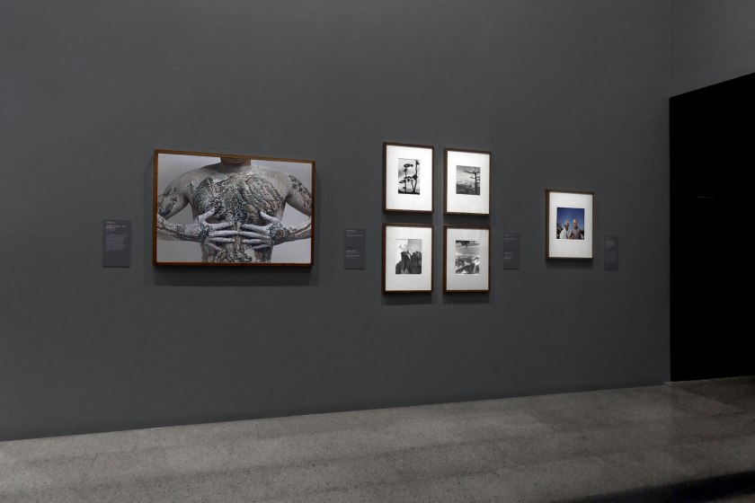 Installation view of the exhibition 'Photography: Real & Imagined' at The Ian Potter Centre: NGV Australia, Melbourne showing from left to right, Huang Yan's 'Chinese landscape – Tattoo (Number 1)' (1999); four photographs by Hedda Morrison (1935); and Mervyn Bishop's 'Prime Minister Gough Whitlam pours soil into the hands of traditional land owner Vincent Lingiari, Northern Territory' (1975)
