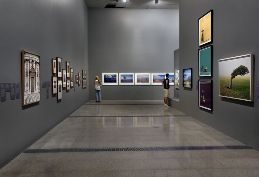 Installation view of the exhibition 'Photography: Real & Imagined' at The Ian Potter Centre: NGV Australia, Melbourne showing at left, Véronique Ellena's 'Santi Luca e Martina, Rome' (2011); at second right, work from Girma Berta's 'Moving shadows' series (2017); and at right, Pieter Hugo's 'Green Point Common, Cape Town' (2013)