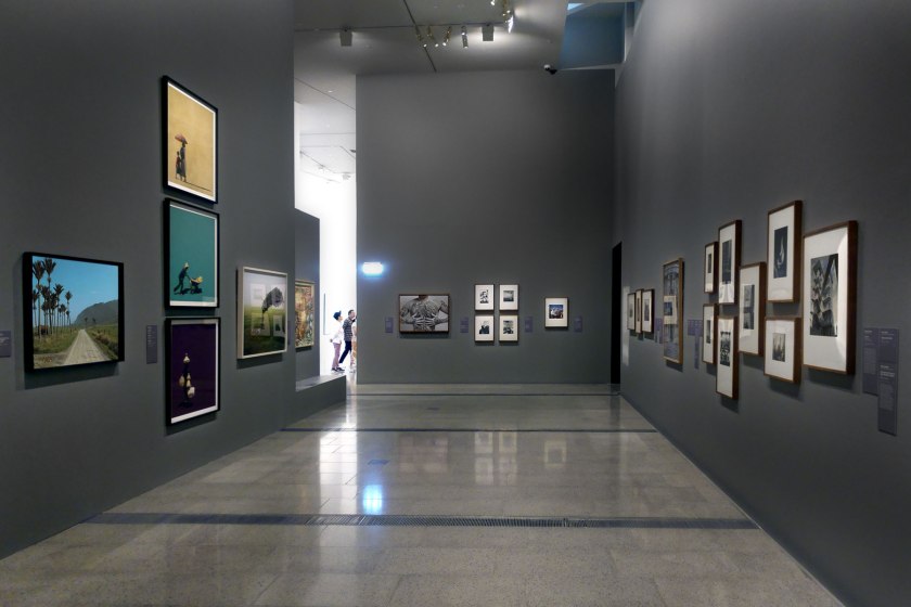 Installation view of the exhibition 'Photography: Real & Imagined' at The Ian Potter Centre: NGV Australia, Melbourne showing at second left, Girma Berta's 'Untitled IV, VI and XII' (2017); and at right, Dacre Stubbs' 'St. George's Road flats' (1953)