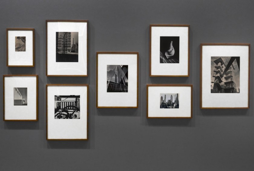 Installation view of the exhibition 'Photography: Real & Imagined' at The Ian Potter Centre: NGV Australia, Melbourne showing from left to right, Gertrude Kasebier's 'Gargoyle' (1901, top); Albert Renger-Patzsch's 'Art d'eglise in Achen' (1930s, bottom); Werner Mantz's 'Industrial Landscape' (1937, top); Max Dupain's 'Silos through windscreen' (1935, bottom); Edward Steichen's 'The maypole' (1932); Barbara Morgan's 'City shell' (1938, top); Berenice Abbott's 'Park Avenue and Thirty-ninth Street, Manhattan, October 8' (1936, bottom) and Dacre Stubbs' 'St. George's Road flats' (1953)