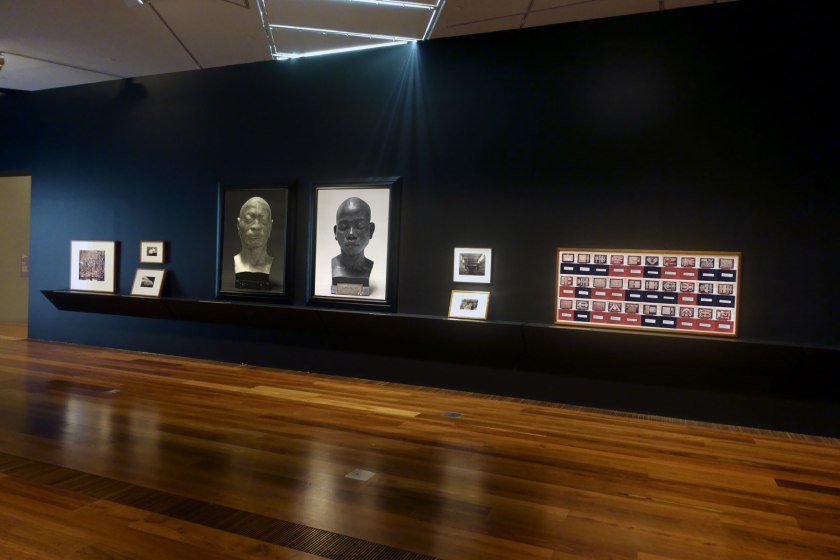 Installation view of the exhibition 'Photography: Real & Imagined' at The Ian Potter Centre: NGV Australia, Melbourne showing at centre, Fiona Pardington's 'Portrait of a life-cast of Koe, Timor' (2010) and 'Portrait of a life cast of Matoua Tawai, Aotearoa New Zealand' (2010); and at right, Linda Judge's 'Victoria and Albert Museum 20/4/94' (1994)