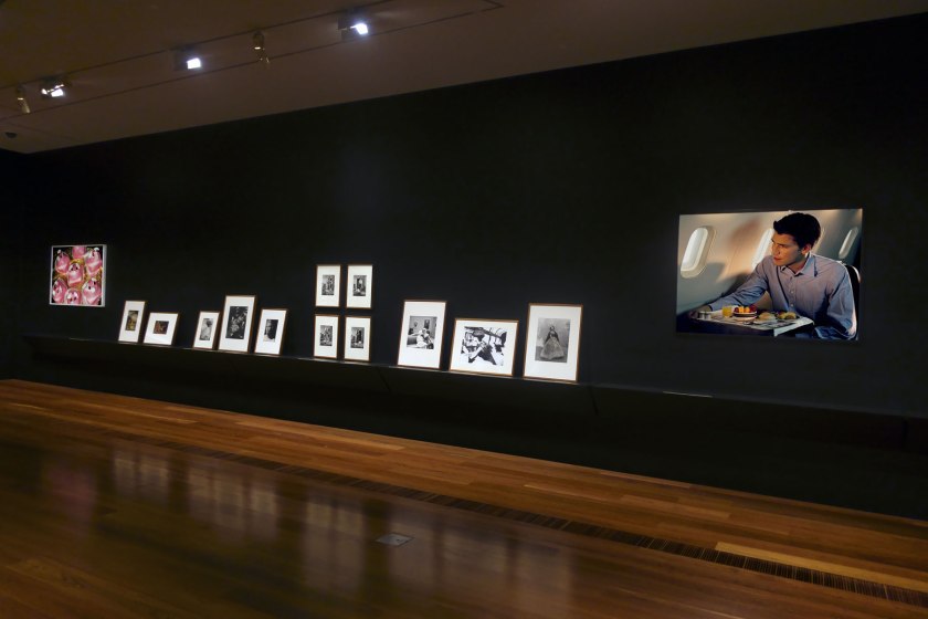 Installation view of the exhibition 'Photography: Real & Imagined' at The Ian Potter Centre: NGV Australia, Melbourne showing at left, Martin Parr's 'Pink Pig Cakes, Bristol, UK' (1995); and at right, Darren Sylvester's 'On Holiday' (2010)